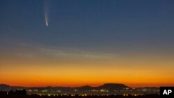 The Comet Neowise or C/2020 F3 is seen before sunrise over Balatonmariafurdo, Hungary, Tuesday, July 14, 2020. It passed closest to the Sun on July 3, and its closest approach to Earth will occur on July 23. (Gyorgy Varga/MTI via AP)