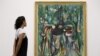 Una mujer observa una obra de arte titulada 'The Sombre Malembo 1943' del pintor surrealista cubano, Wifredo Lam, durante una sesión fotográfica para promover una exposición de la obra del artista, en la galería Tate Modern de Londres.