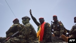 Letkol Mamady Doumbouya (tengah), kepala pasukan khusus Angkatan Darat dan pemimpin kudeta, melambaikan tangannya ke kerumunan saat ia tiba di Istana Rakyat di Conakry pada 6 September 2021, menjelang pertemuan dengan para Menteri Mantan Presiden Guinea, Alpha Conde.
