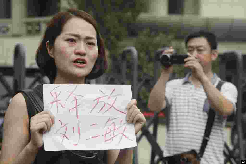 被拘押的律师王全璋的妻子李文足在天津第二中级人民法院门前抗议,李文足手举标语“释放刘二敏”(2016年8月1日) 。刘二敏是人权人士翟岩民的妻子,2018年4月5日和李文足一起在北京郊区游行。