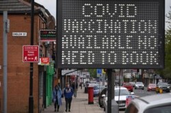 FILE - A digital board advises the public that COVID-19 vaccines are available as a virus variant affects the community in Bolton, northwest England, May 14, 2021.
