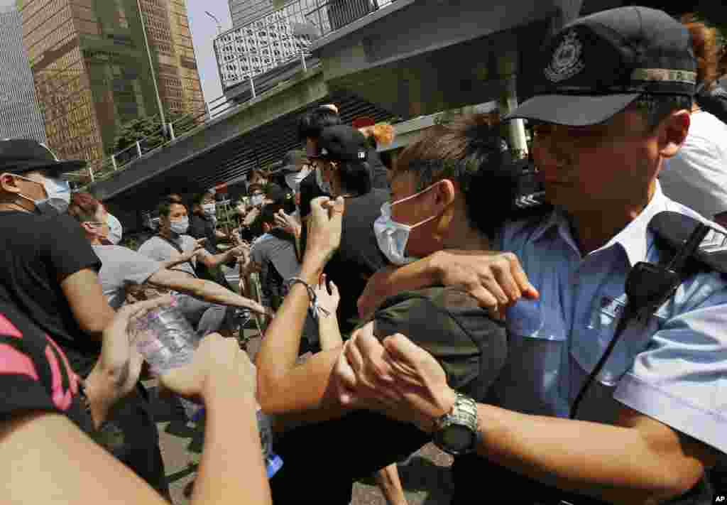 An angry crowd charged barricades used by pro-democracy protesters to occupy part of downtown Hong Kong, as a standoff with authorities dragged into a third week, Hong Kong, Oct. 13, 2014.