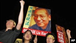 图为去年10月8日香港民众高举当年诺奖获得者刘晓波的照片举行抗议要求释放他