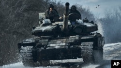 Ukrainian soldiers ride atop a tank on the front line in Bakhmut, Donetsk region, Ukraine, Feb. 20, 2023. On Feb. 24, 2023, it was reported that Moscow’s forces had made progress trying to encircle Bakhmut.