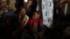 FILE - Children sit inside a container truck as they wait to depart to the west of the country towards the border with Cameroon, in a convoy escorted by African Union (AU) peacekeeping forces as they flee sectarian violence in the capital Bangu.