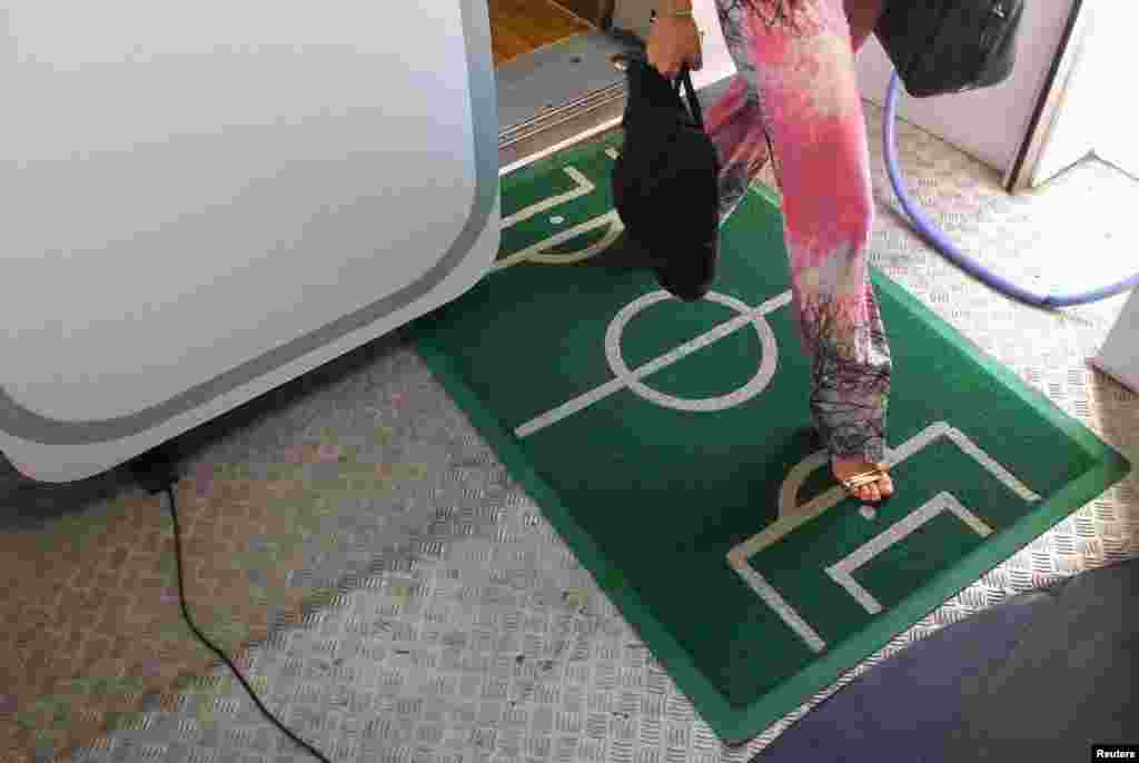 Karpet menyerupai lapangan sepakbola ditempatkan di pintu keluar pesawat di bandar udara Belem, Brazil (15/6). (Reuters/Yves Herman)