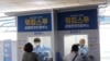 FILE - Medical workers in a booth take samples from people for COVID-19 tests at a makeshift clinic in Seoul, South Korea, Aug. 20, 2020.