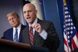 FILE - FDA Commissioner Dr. Stephen Hahn speaks as U.S. President Donald Trump listens during the daily briefing on the novel coronavirus, COVID-19, in the Brady Briefing Room of the White House, April 21, 2020.