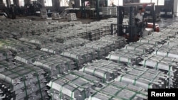 FILE - A worker drives a forklift to transport aluminum bars at a factory in Anshun, Guizhou province, China, July 1, 2013.