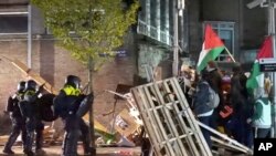 En esta imagen tomada de un video, la policía arresta a unos 125 activistas al desmantelar una acampada pro-Palestina en la Universidad de Ámsterdam, en Ámsterdam, Holanda, el 7 de mayo de 2024.