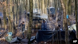 Migranti prave sklonište od plastičnih prekrivača i drveta u improvizovanom kampu u šumi pored Velike Kladuše, Bosna i Hercegovina, 5. januara 2021.