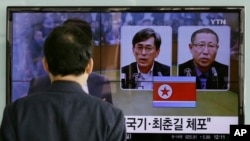 Seorang pria di Seoul menonton berita televisi mengenai dua pria Korea Selatan yang ditahan di Korea Utara (27/3). (AP/Ahn Young-joon)