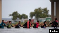 Los migrantes cruzan el río Grande para intentar solicitar asilo a través de Eagle Pass, Texas, EEUU, visto desde Piedras Negras, México, el 27 de septiembre de 2023.