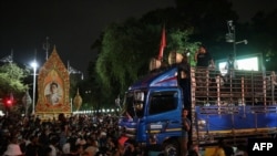 Aktivis pro-demokrasi Parit "Penguin" Chiwarak (kanan) berbicara dengan pengeras suara dari truk kepada para pengunjuk rasa selama unjuk rasa antipemerintah di sebelah Gedung Pemerintah di Bangkok pada 14 Oktober 2020. (Foto: AFP/Jack Taylor)
