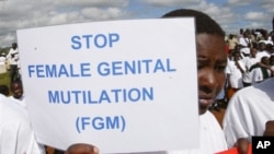 FILE - Masai girl holds protest sign during anti-Female Genital Mutilation (FGM) run in Kilgoris, Kenya