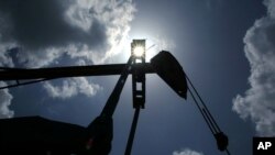 FILE - Oil is pumped from a well near Van, Texas.