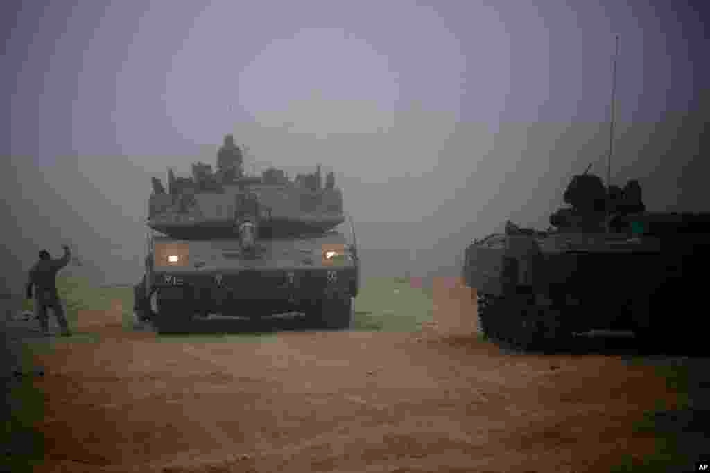 An Israeli tank moves through the morning mist near the Israel and Gaza border, July 24, 2014.
