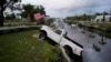 Una camioneta con una bandera estadounidense atada se encuentra a medio camino de un canal en Horseshoe Beach, Florida, después del paso del huracán Idalia, el 30 de agosto de 2023.