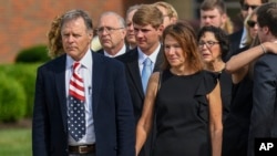 FILE - Fred and Cindy Warmbier watch as their son Otto's casket is placed in a hearse after funeral services, in Wyoming, Ohio, June 22, 2017.