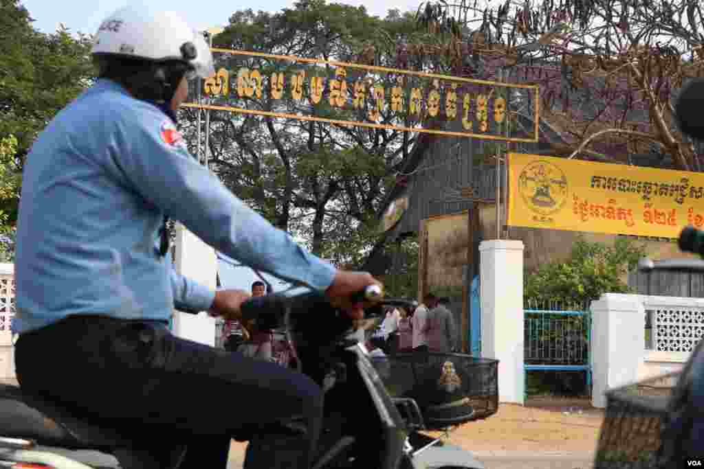 ប៉ូលិសចរាចរណ៍ម្នាក់បើកបរម៉ូតូកាត់មណ្ឌលបោះឆ្នោតព្រឹទ្ធសភាមួយកន្លែង នៅសាលាបឋមសិក្សាកំពង់ធំក្រុង ក្នុងខេត្តកំពង់ធំ នាព្រឹកថ្ងៃអាទិត្យ ទី២៥ ខែកុម្ភៈ ឆ្នាំ២០១៨។ (ស៊ុន ណារិន/VOA)