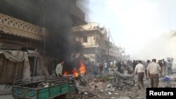 People inspect a site hit by what activists said were barrel bombs dropped by forces loyal to Syria's President Bashar al-Assad in the northern town of Atareb, in Aleppo province, Apr. 24, 2014. 