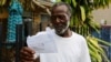 William Jones, upset with the unresponsiveness of his electric company, displays his monthly bill. “Answer the phone when you call them,” he complains. “Answer the phone.” (Photo: R. Taylor / VOA) 