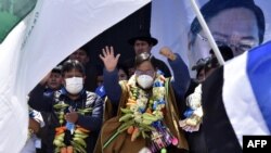 El presidente electo de Bolivia, Luis Arce y el vicepresidente electo, David Choquehuanca, celebran su victoria en las elecciones generales durante un mitin en El Alto, Bolivia, el 24 de octubre de 2020.