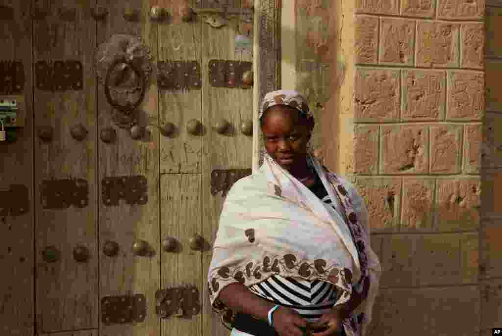 This May 1, 2012 photo shows a woman in front of a traditionally decorated door in Timbuktu, Mali.