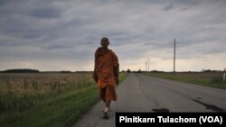 Buddhist monk Sutham Nateetong walks along the road outside Arcola, IN. June 8, 2019.