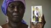 FILE - Martha Mark, mother of kidnapped schoolgirl Monica Mark, cries as she displays her photo in the family's house in Chibok, Nigeria, May 19, 2014
