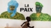 A boy runs in front of a mural that reads "Peace", in Timbuktu, July 24, 2013. 
