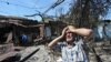 An ethnic Uzbek holds his head in his hands as he stands beside the wreckage of his burned out home in Osh, 14 June 2010