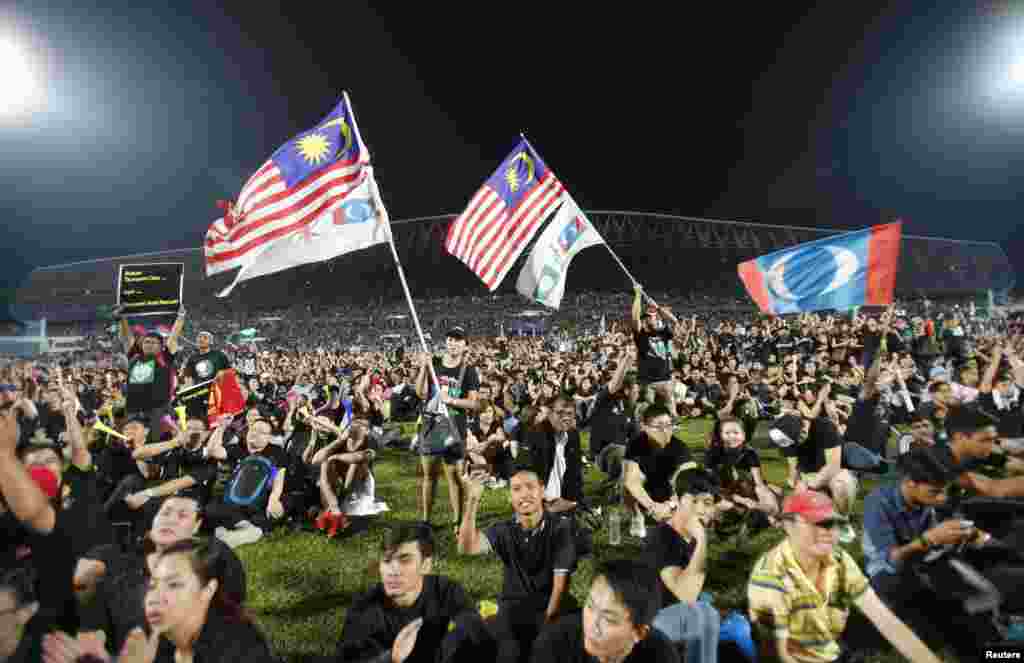 Opposition supporters wave flags as they attend a rally to protest Sunday's election results at a stadium in Kelana Jaya, Malaysia, May 8, 2013.