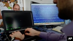FILE - Employees work at the headquarters of Bitdefender, a leading Romanian cyber security company, in Bucharest, Romania. 
