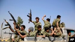 FILE - Shiite fighters, known as Houthis, ride on a patrol truck as they chant slogans during a tribal gathering showing support for the Houthi movement in Sanaa, Yemen. 