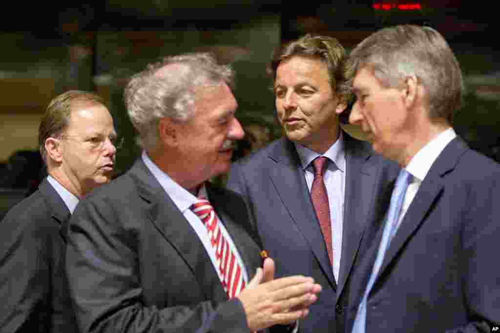 Dutch Foreign Minister Bert Koenders, center, speaks with Luxembourg's Foreign Minister Jean Asselborn, second left, and British Foreign Minister Philip Hammond, right, during a round table meeting of EU foreign ministers in Luxembourg on Monday, Oct. 20, 2014. European Union nations are working to find funds to help fight Ebola in West Africa and streamline a common approach in dealing with the health crisis.