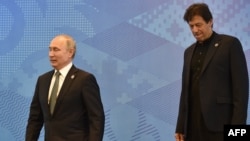Presiden Rusia Vladimir Putin dan Perdana Menteri Pakistan Imran Khan sebelum pertemuan Dewan Kepala Negara Organisasi Kerjasama Shanghai (SCO) di Bishkek pada 14 Juni 2019. (Foto: AFP/Vyacheslav Oseledko)