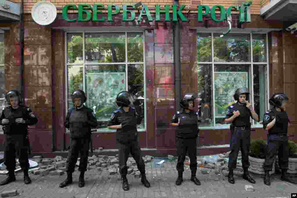 Riot police protect an office of the Russian Sberbank after people attacked it with the stones in Kyiv, June 22, 2014.