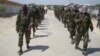 FILE - Members of Somalia's al- Shabab militant group march on the outskirts of Mogadishu, Somalia, March, 5, 2012. A U.S. drone strike Friday reportedly killed a top al-Shabab recruiter.