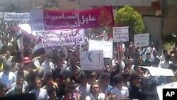 An image taken from YouTube shows Syrian anti-regime protesters marching during a rally in the northeastern city of Kafr Nabl, June 3, 2011