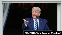 Presiden AS Donald Trump berdiri di balkon Gedung Putih berbicara kepada para pendukung yang berkumpul di South Lawn untuk rapat umum kampanye. (Foto: Reuters)