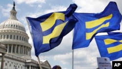 Para pengunjuk rasa mengibarkan 'bendera kesetaraan' untuk mendukung warga transgender yang bertugas di militer AS, di Capitol Hill, Washington, 26 Juli 2017.