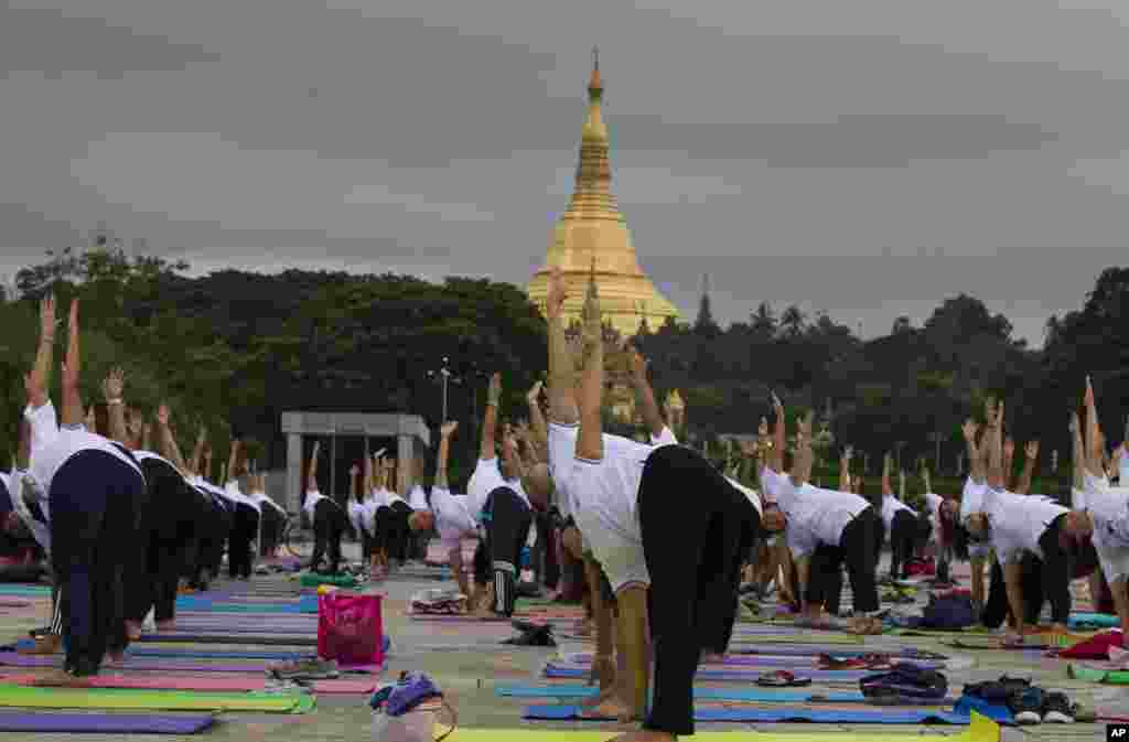 在缅甸仰光的仰光大金寺或称雪德宮大金塔( Shwedagon pagoda)旁边,瑜伽爱好者们专心练习(2017年6月21日)