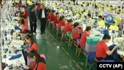 资料照：中国新疆和田一所职业教育训练中心的穆斯林学员在服装厂里工作。(2019年1月9日)