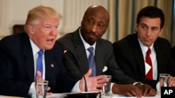 FILE - In this Feb. 23, 2017 photo, President Donald Trump, left, speaks during a meeting with manufacturing executives, including Merck CEO Kenneth Frazier, center, and Ford CEO Mark Fields. Frazier is resigning from the President’s American Manufacturing Council.