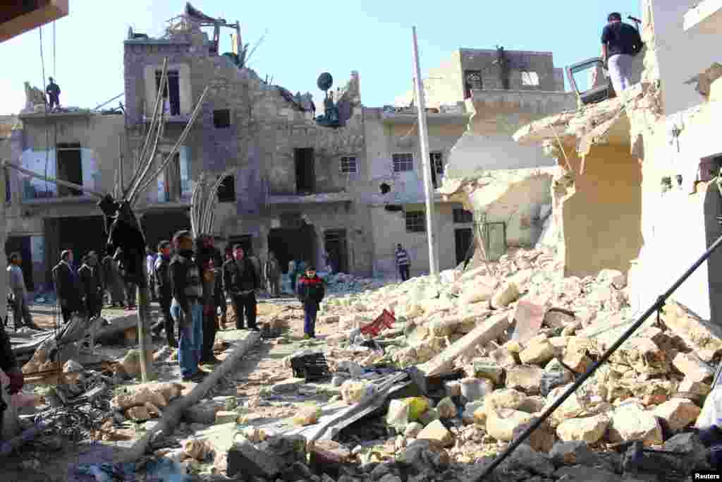 Residents inspect a damaged site after what activists said was an air strike by forces loyal to Syria's President Bashar al-Assad in Karam Al-Beik, Aleppo, Jan. 21, 2014.