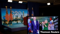 Joe Biden y su esposa, Jill Biden, vistos a través de una pantalla instantes después de conocerse que el exvicepresidente será el candidato demócrata en las elecciones de noviembre.