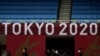 Staf berjalan di bawah logo Tokyo 2020 di lapangan permainan judo di Nippon Budokan menjelang Olimpiade Musim Panas 2020, Jumat, 23 Juli 2021, di Tokyo, Jepang. (Foto: AP/Vincent Thian)
