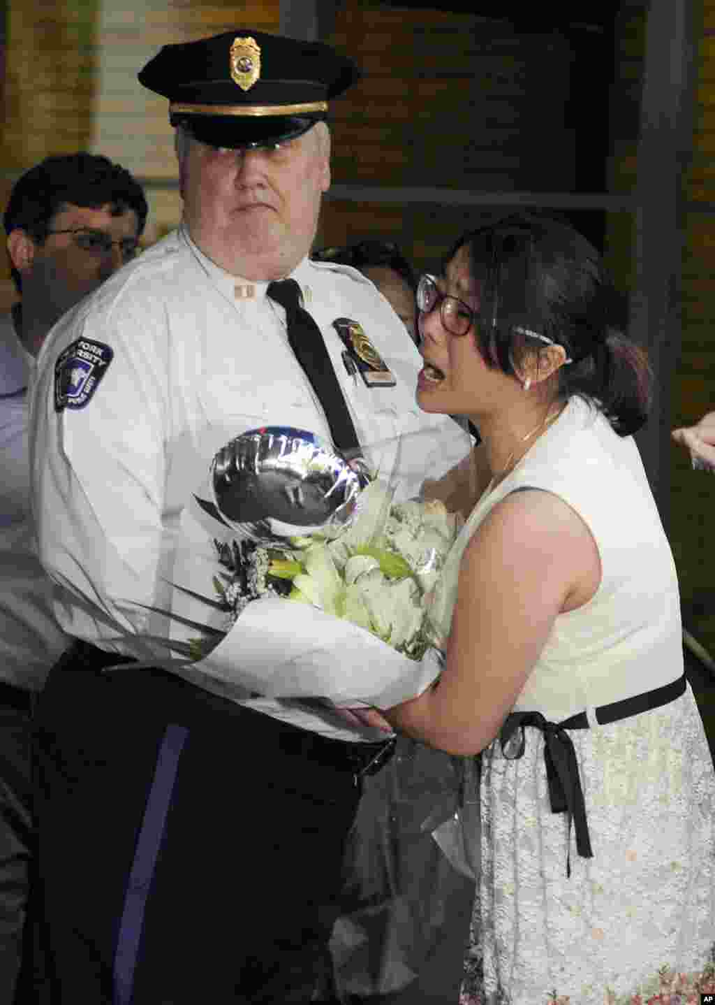 A woman is held back by security as she tries to get the attention of blind Chinese legal activist Chen Guangcheng after he arrived on the campus of New York University, May 19, 2012, in New York.