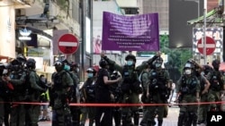 Police officers raise a warning banner at a downtown street in Hong Kong, Sept. 6, 2020. 